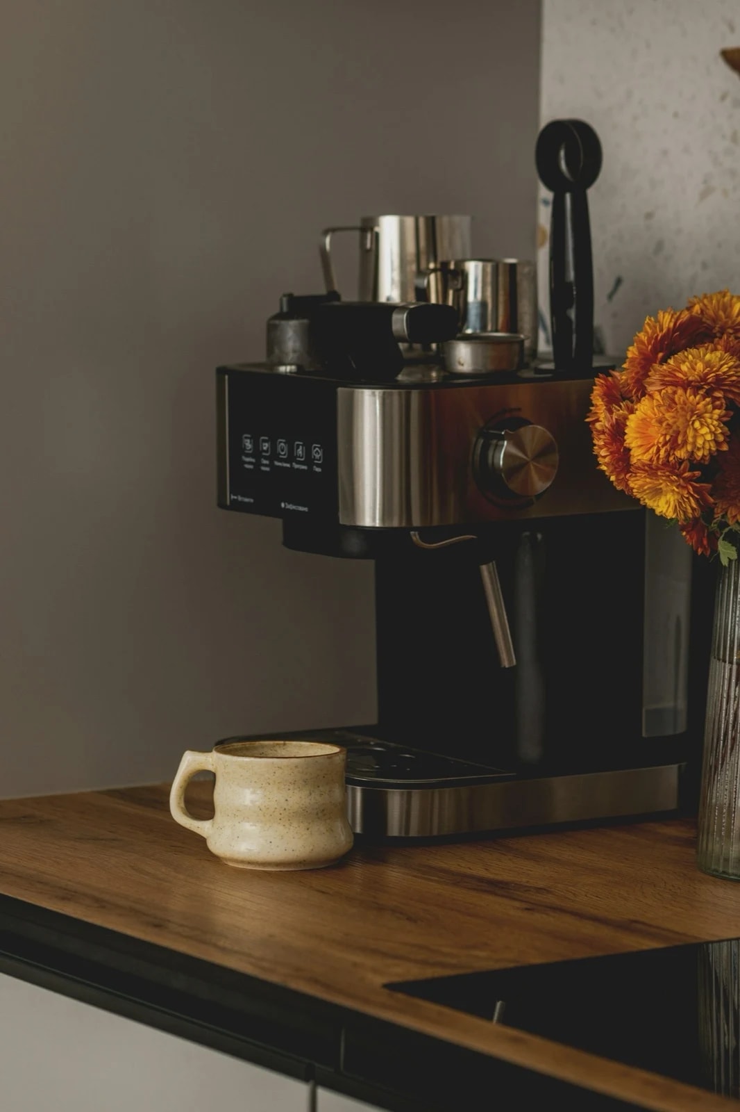 An espresso machine and a coffee cup on a wooden kitchen counter